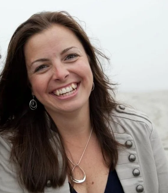 Female business owner Jackaline Rutter smiling and wearing a taupe sweater.