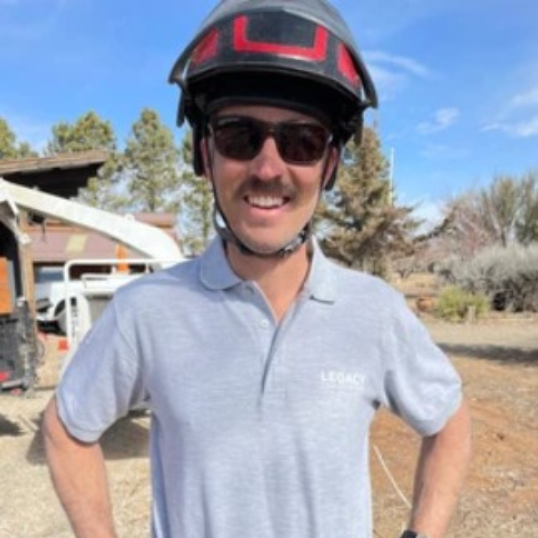a person wearing a helmet and sunglasses standing in front of a truck.