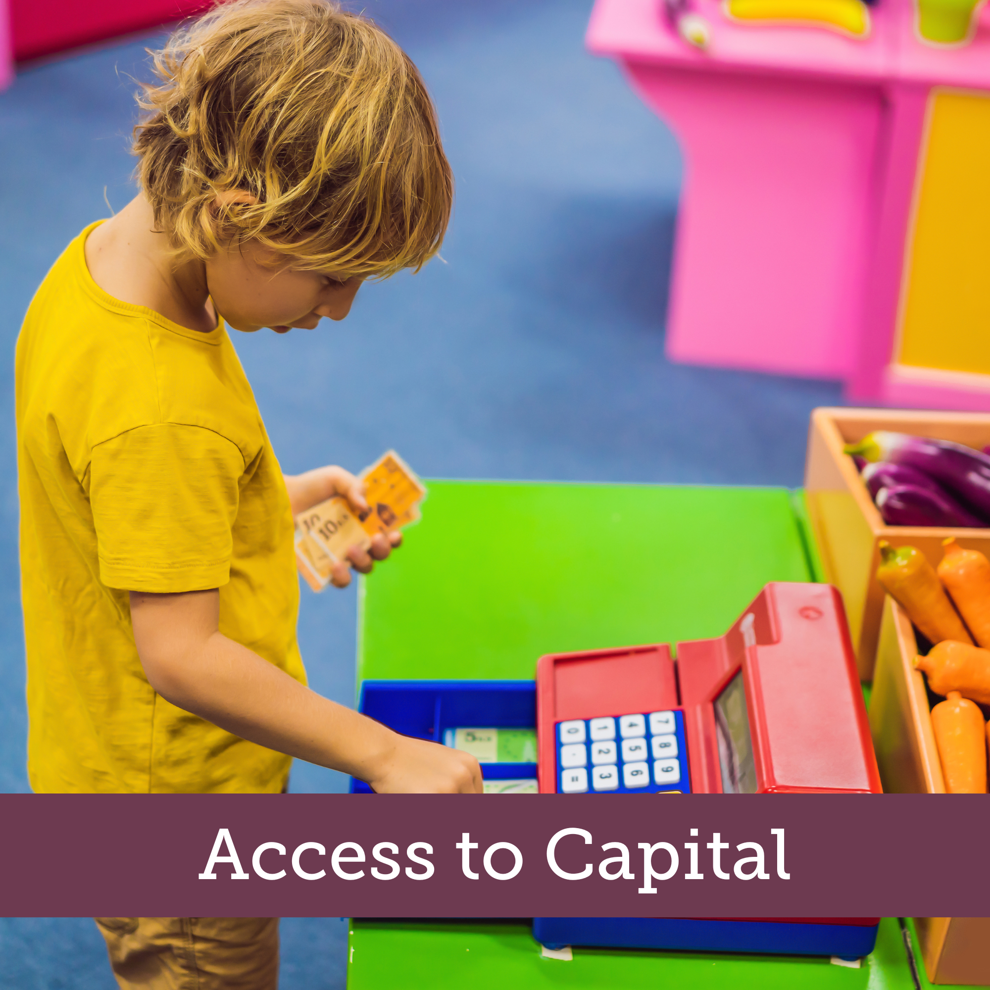 a boy standing in front of a toy cash register with a banner that reads access to capital