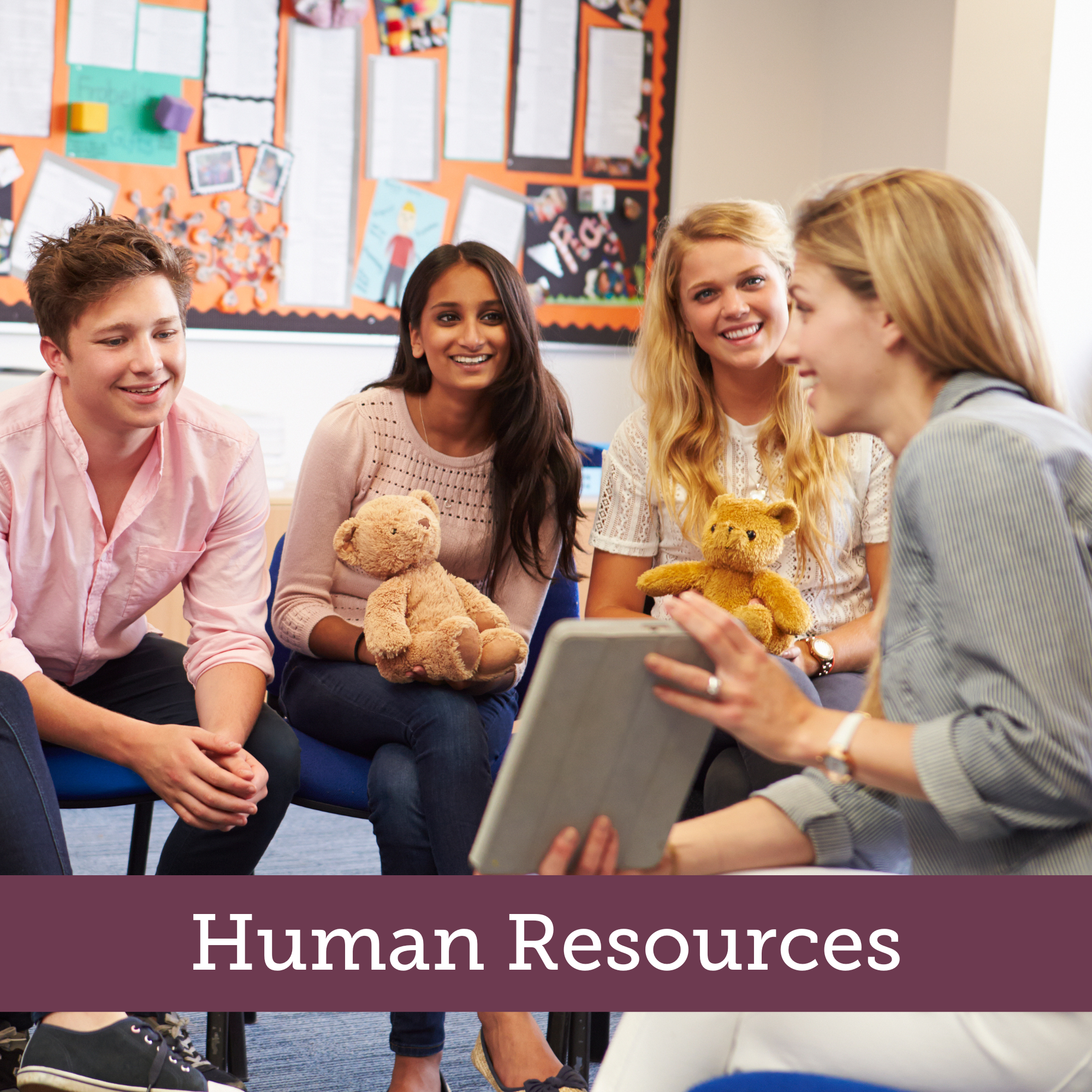 A group of people sitting around a table with a teacher with a banner that reads staff development with a banner that reads Human Resources. 