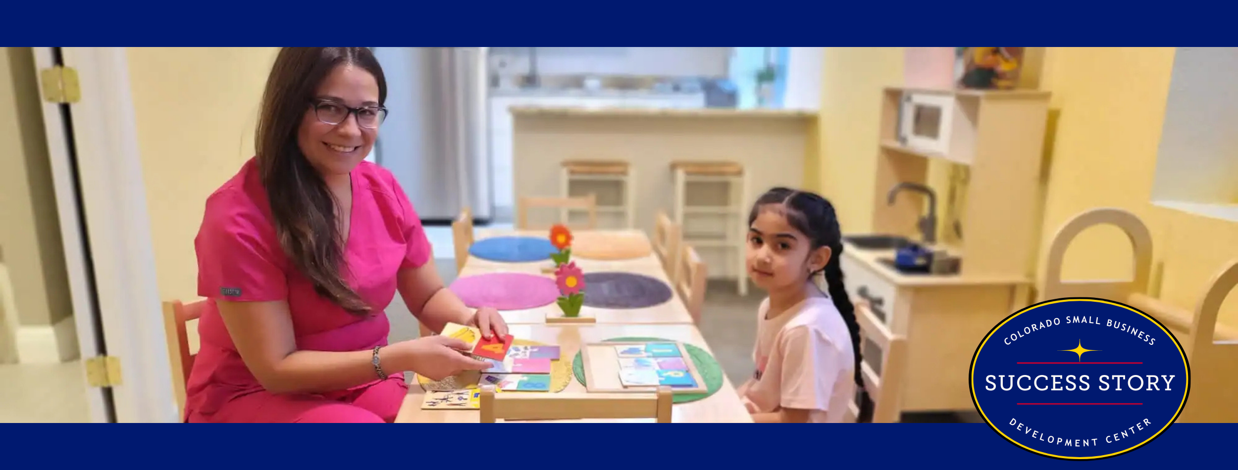a person in pink is sitting at a table with a child.