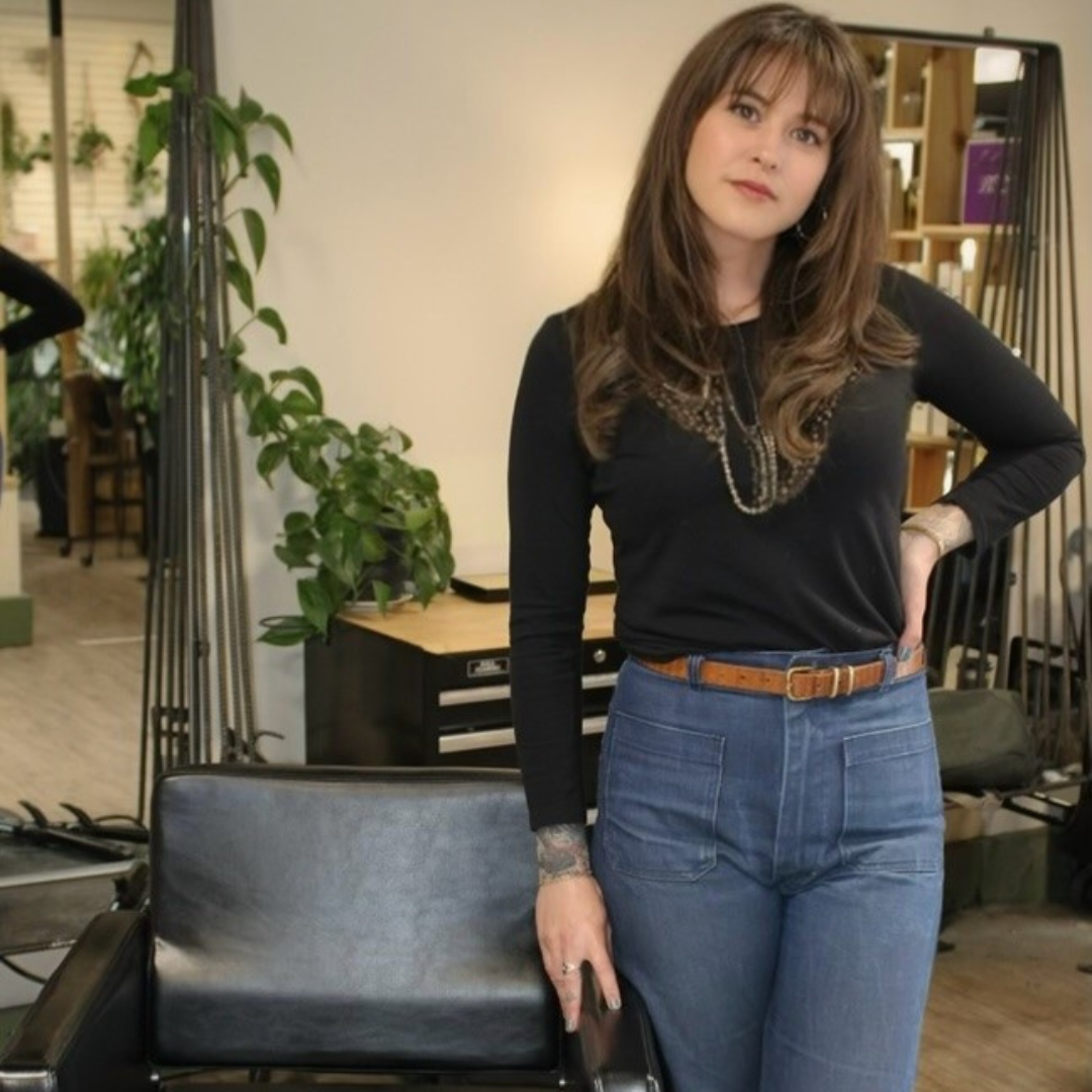 a person standing in front of a chair in a salon.