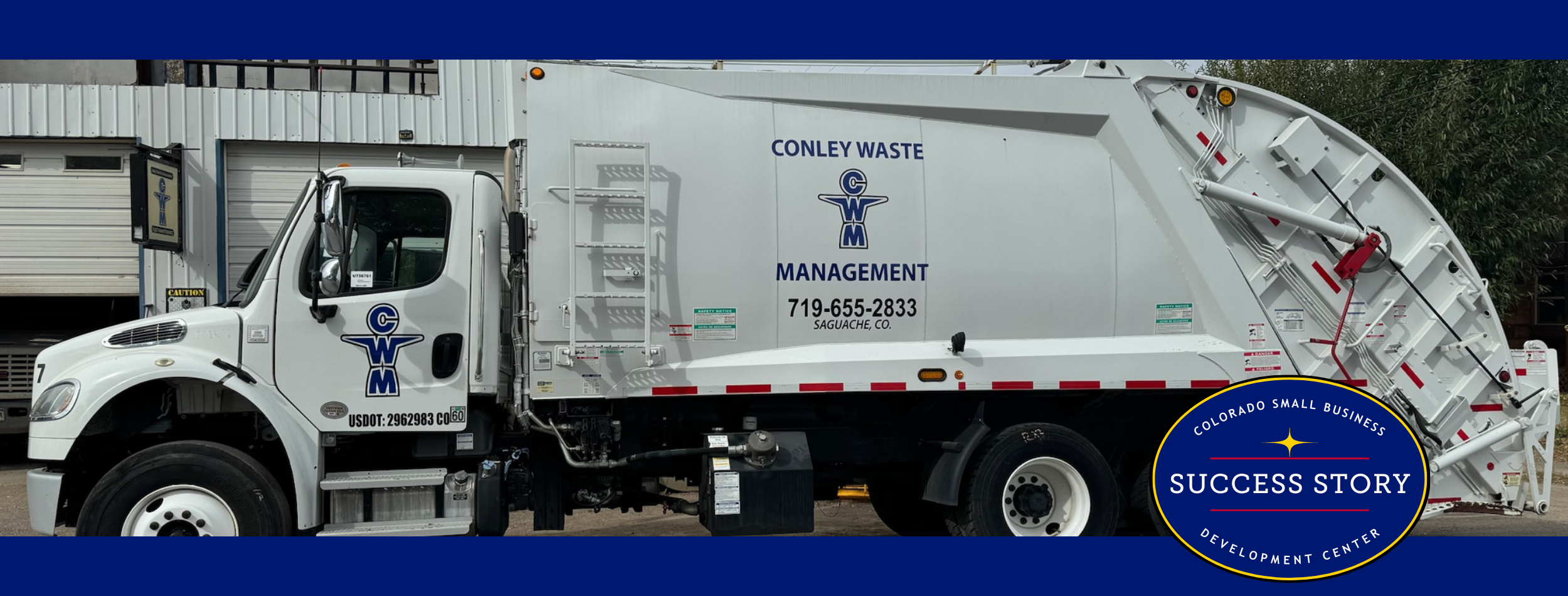 a large garbage truck parked in front of a building.