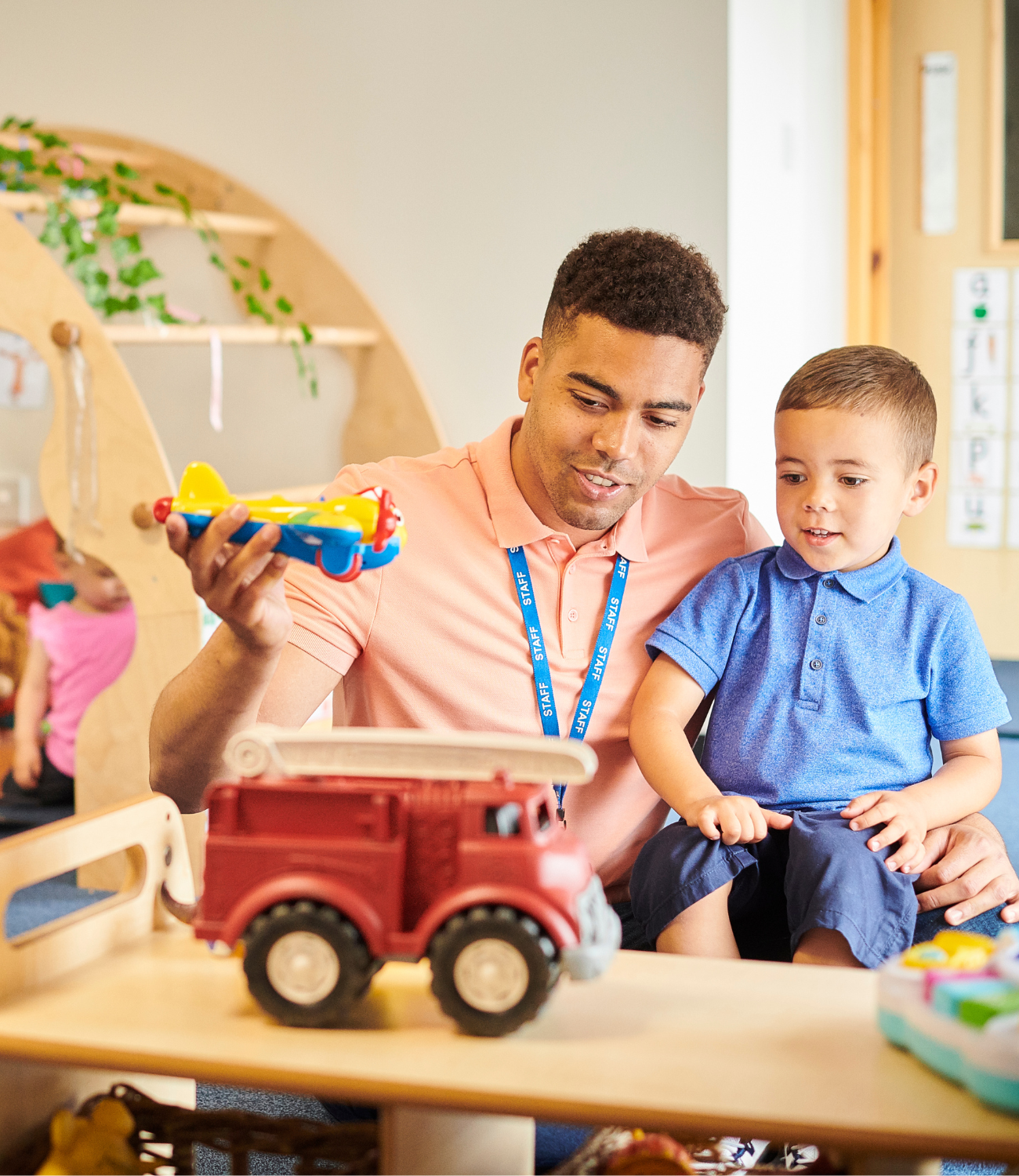 a person and a child playing with toys in a playroom.
