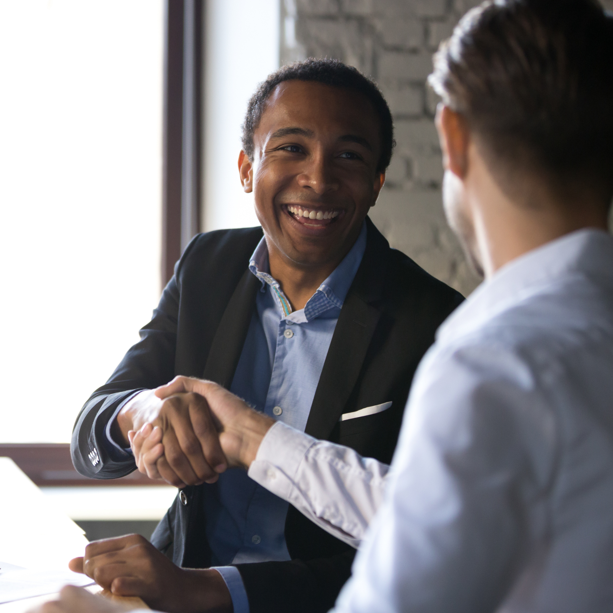 two people shaking hands at a business meeting.
