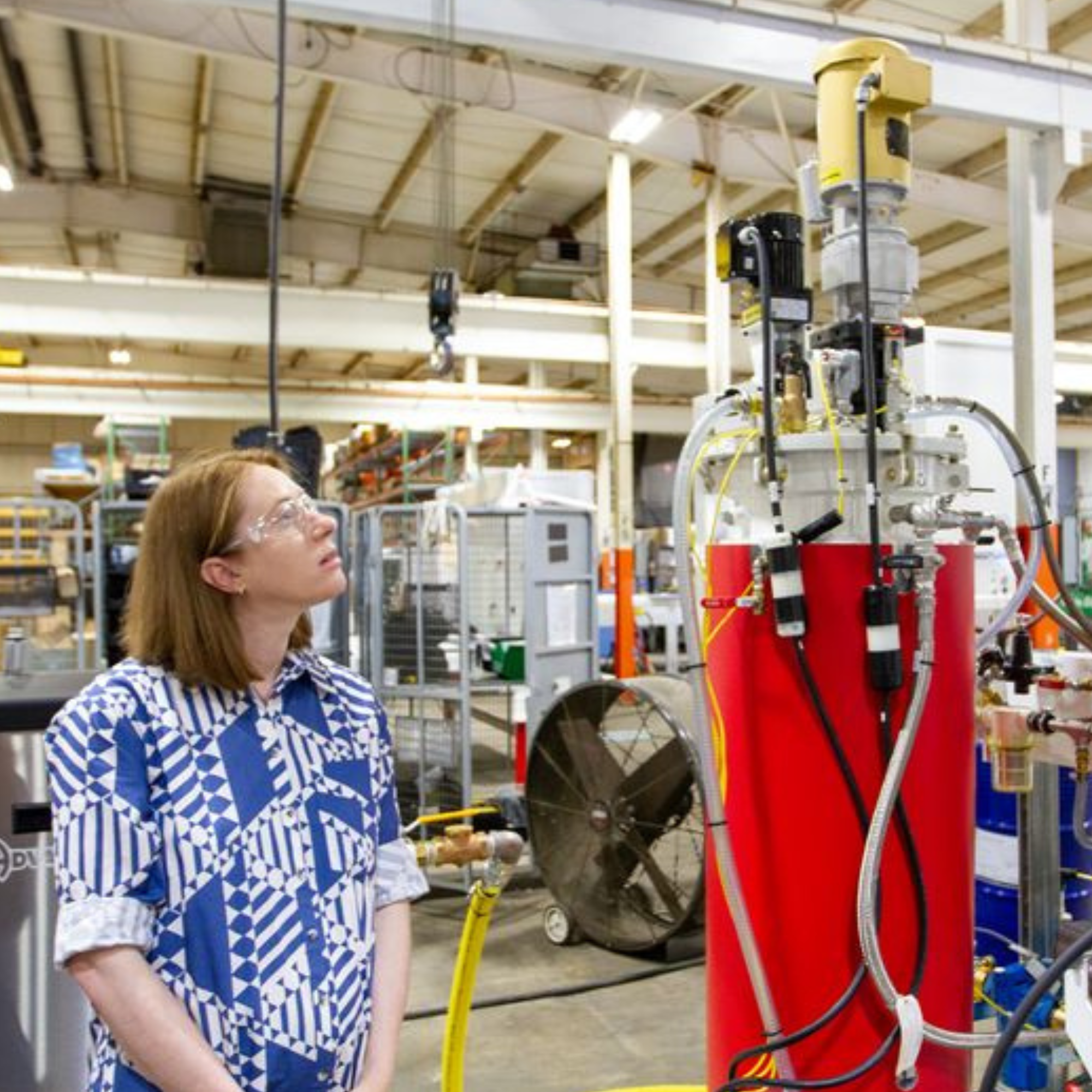 a person standing next to a device in a lab.