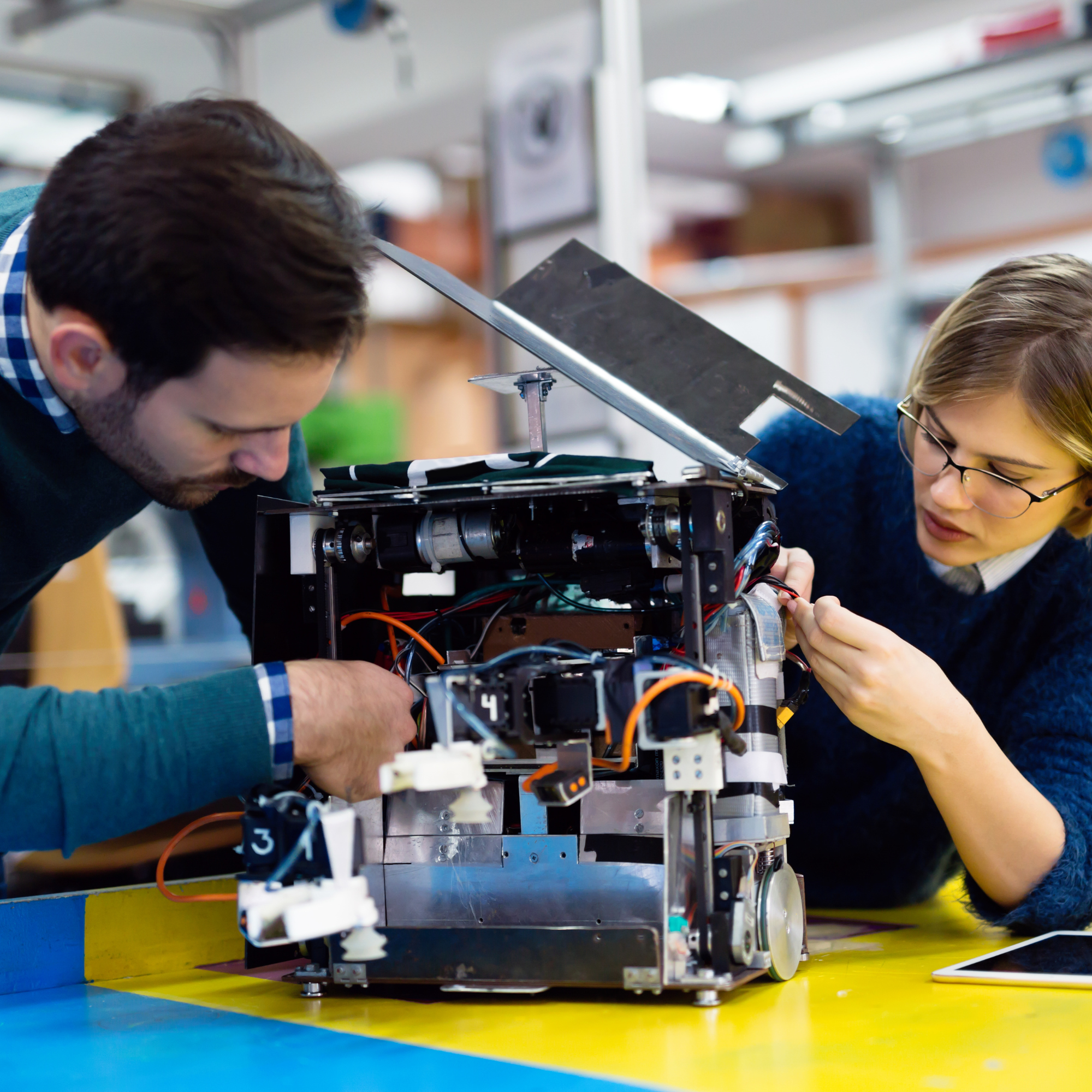 Two people working on an electronic device.