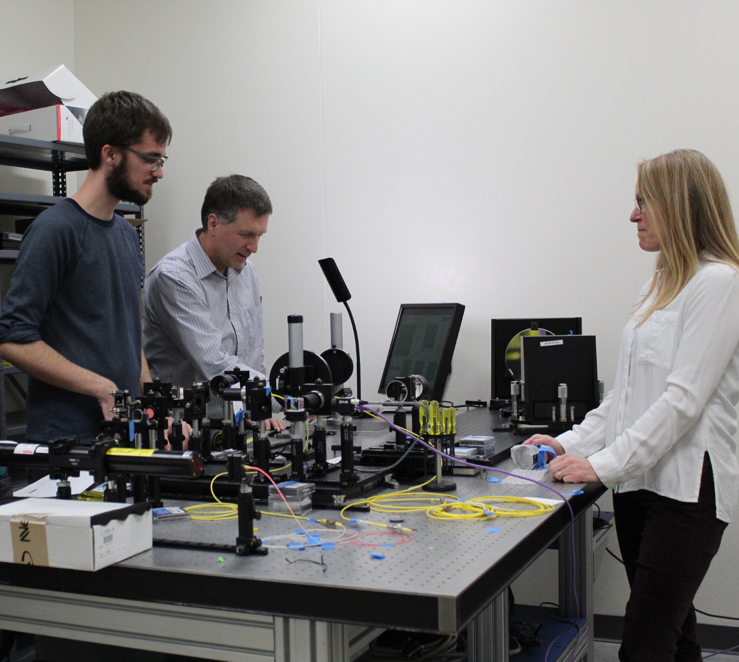 a group of people standing around a table in a lab.