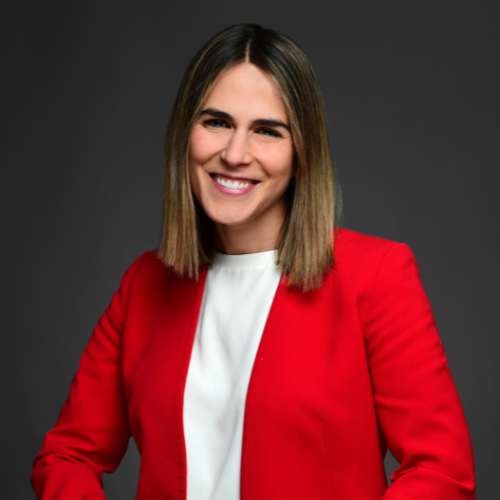 Woman wearing a red blazer and white shirt smiling.