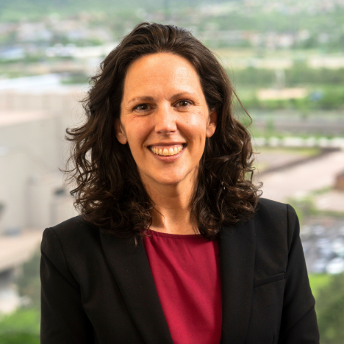 smiling person wearing black blazer and red shirt