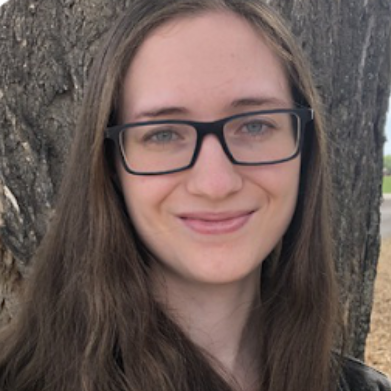 Woman with long brown hair and glasses smiling