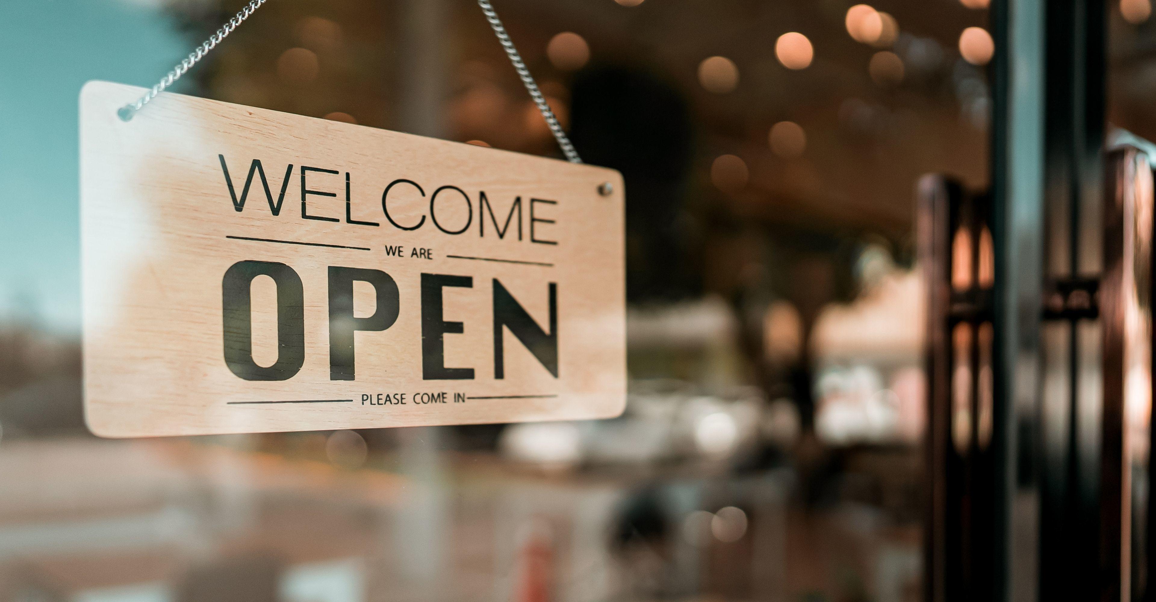 Welcome we are open sign displayed in a window