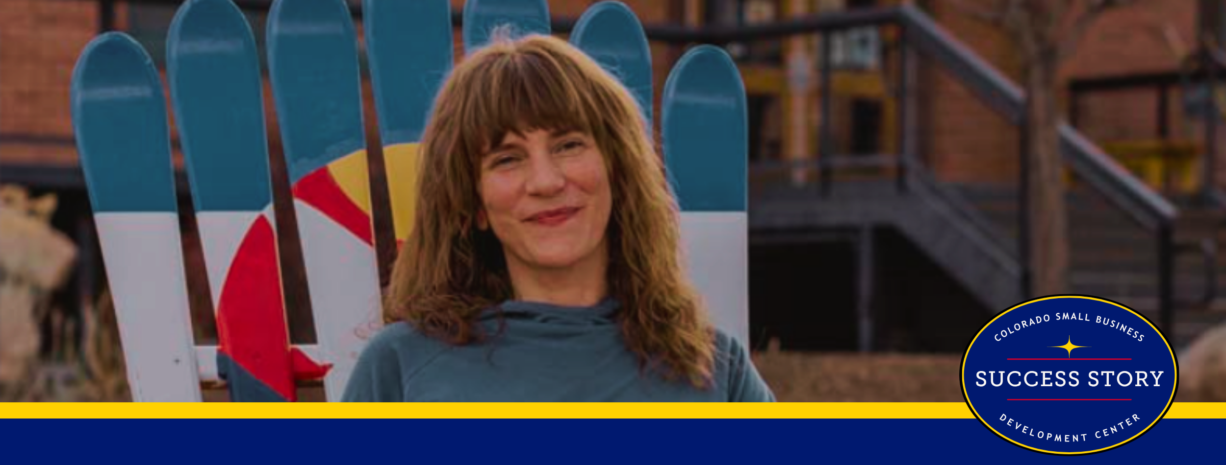 a person sitting in an adirondack chair in front of a building.