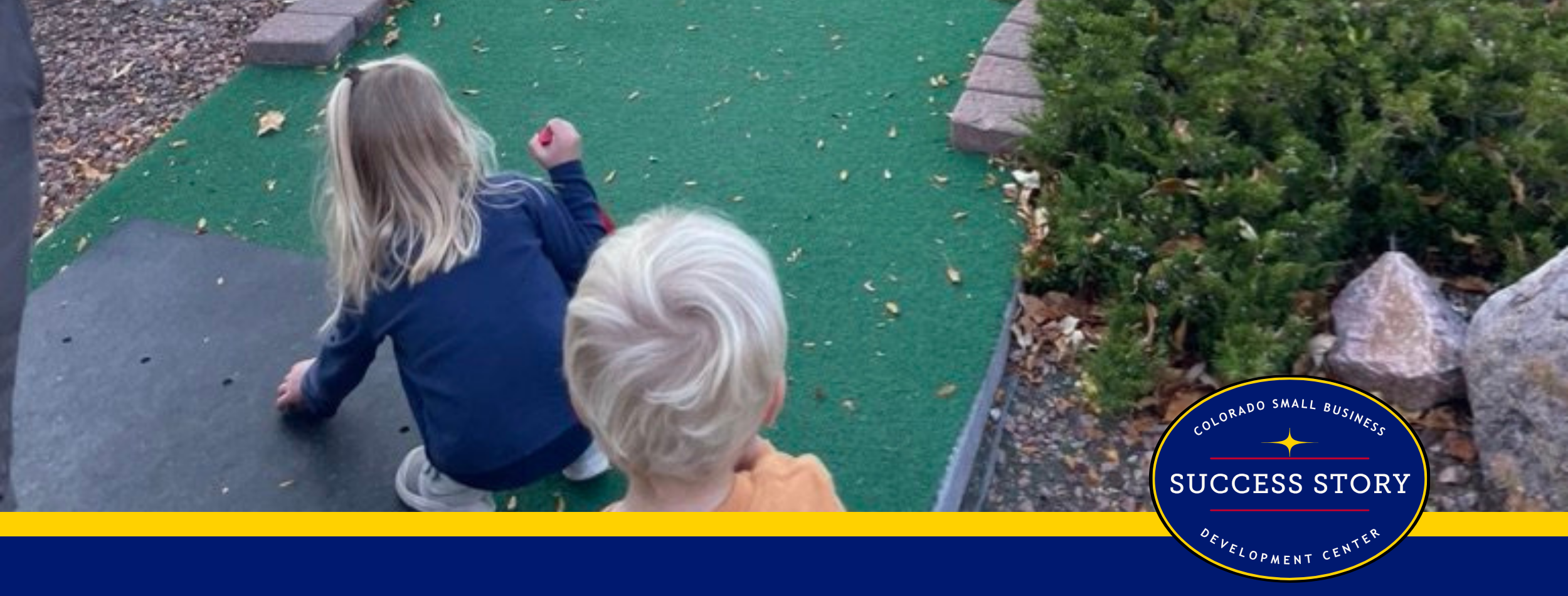 children playing mini golf on a course.