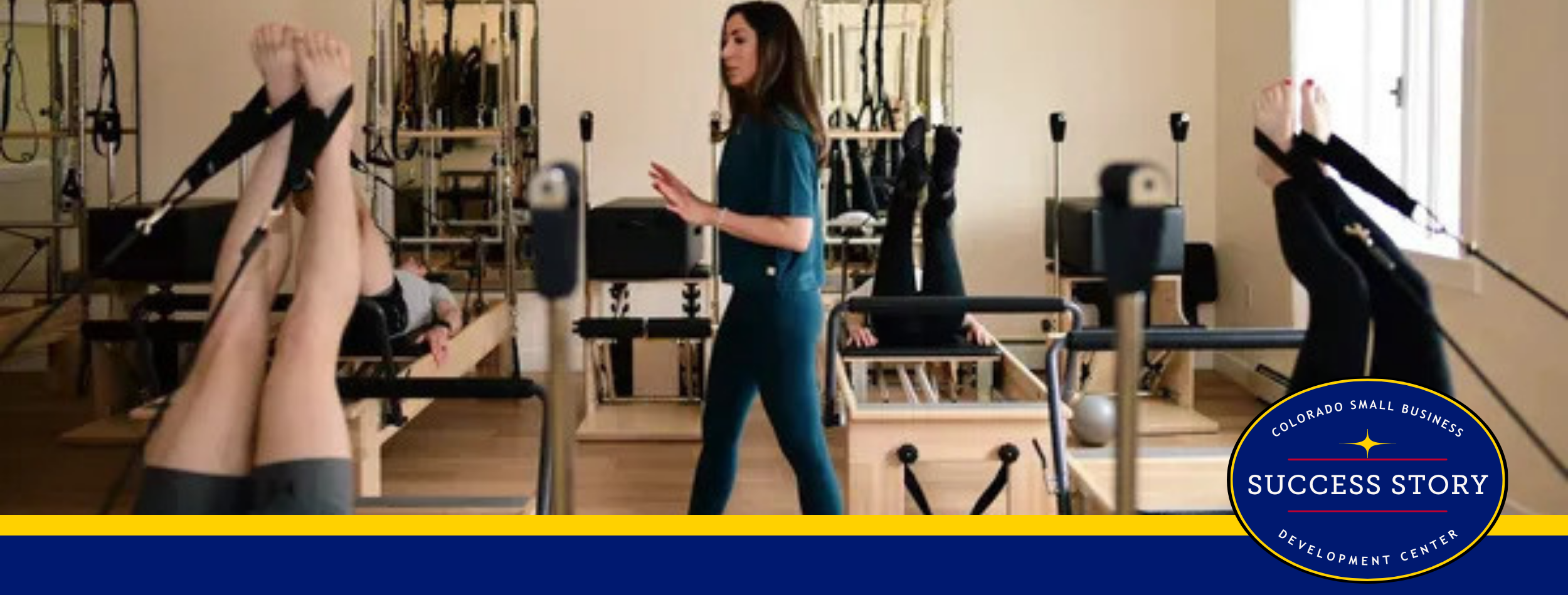 A Pilates instructor in a teal outfit demonstrates exercises on a reformer machine to clients on similar machines.
