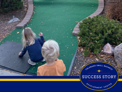 children playing mini golf on a course.