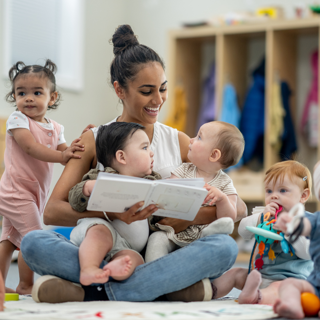 a person is reading to a group of babies.