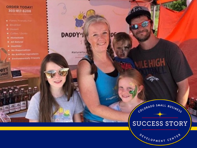 A family poses for a photo in front of a booth.