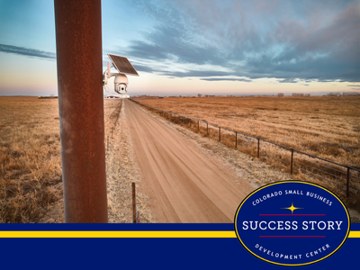 a pole with a solar panel on it in the middle of a dirt road.