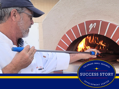 a person in a white shirt is putting wood into a brick oven.