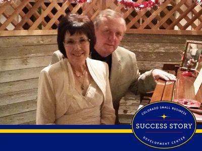A couple posing for a photo in front of a piano.