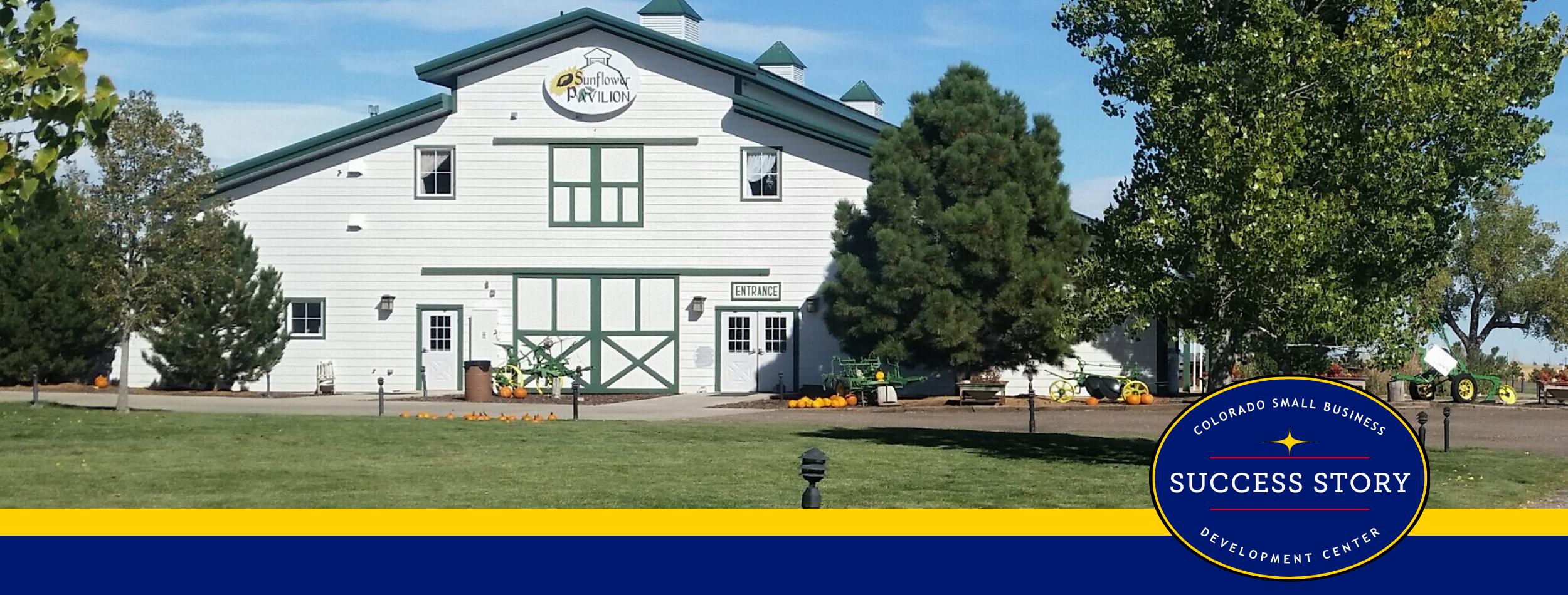 a large barn-like structure next to farm equipment.