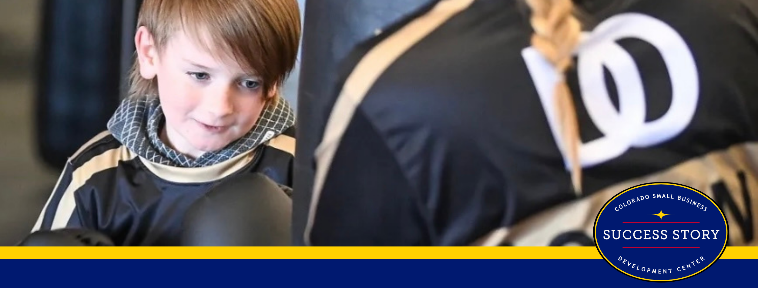 A boy is wearing boxing gloves in a gym.