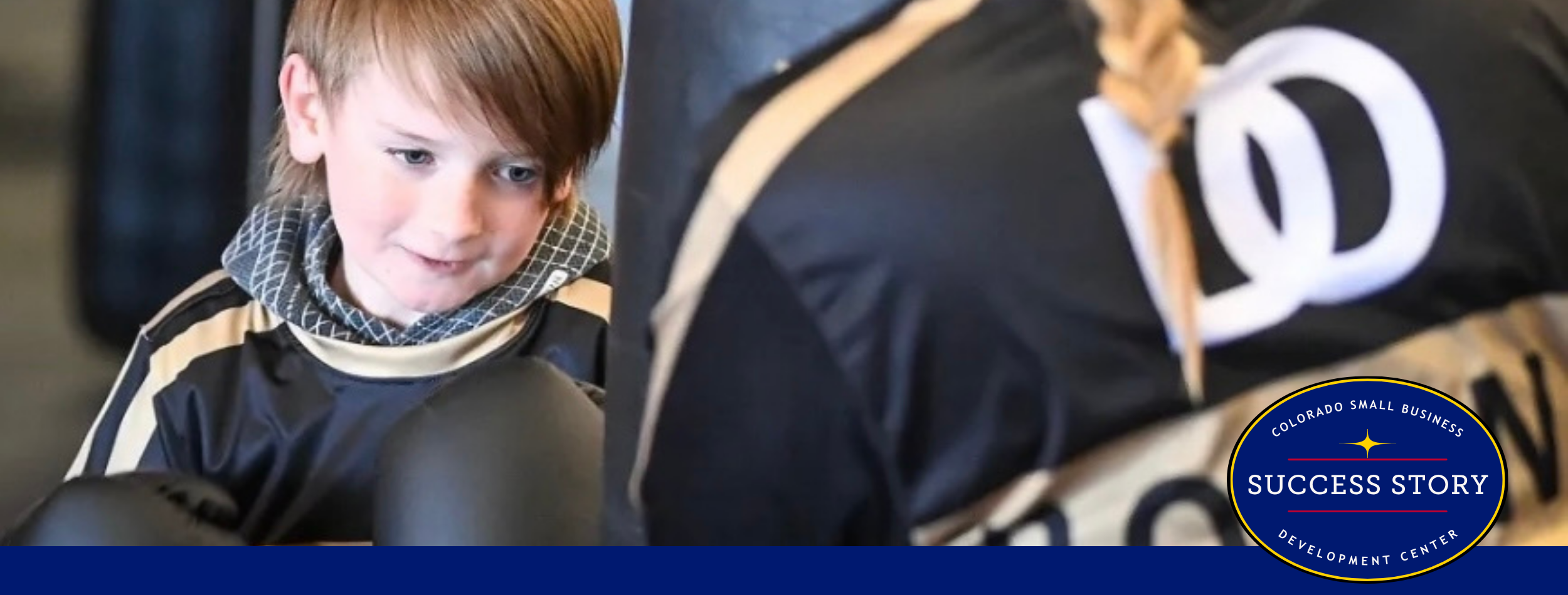A boy is wearing boxing gloves in a gym.