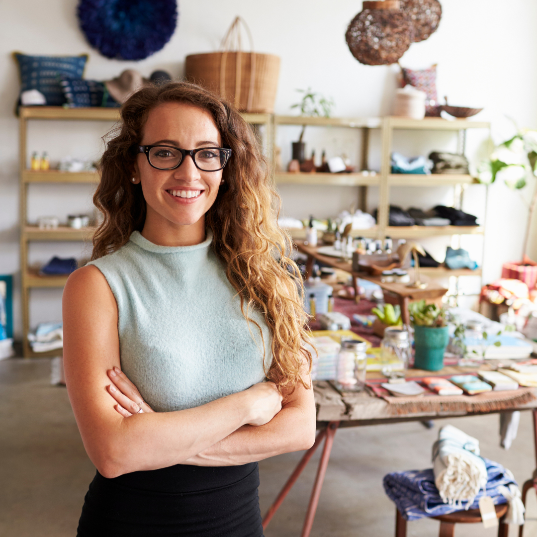 a person with glasses standing in front of a shop.