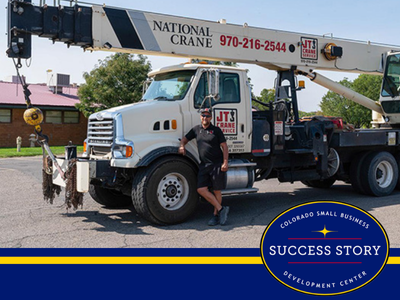 a person standing next to a crane truck in a parking lot.