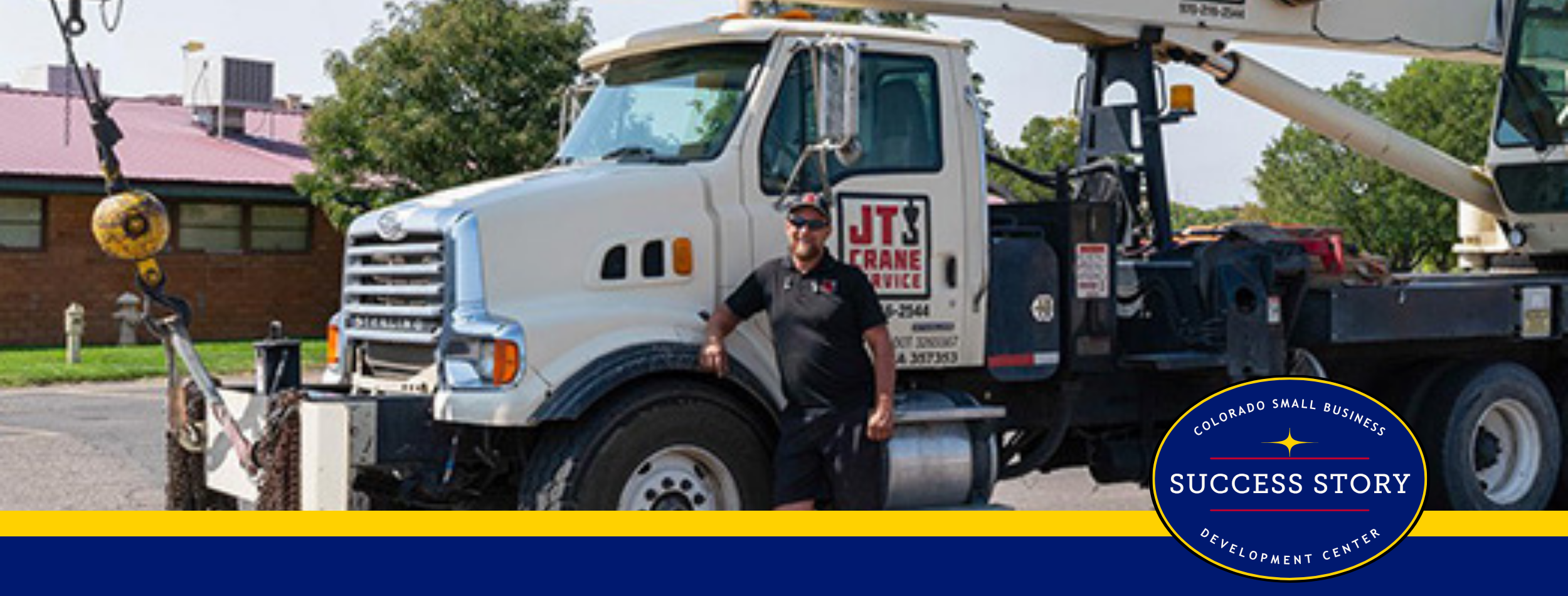 a person standing next to a large white truck with a crane.