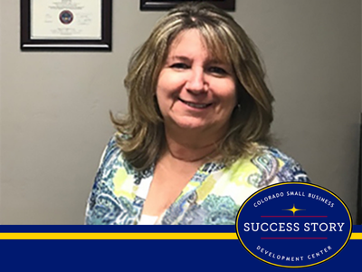 A person is standing in front of a wall with certificates in frames.