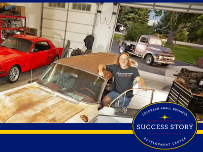 a person standing next to an old car in a garage.