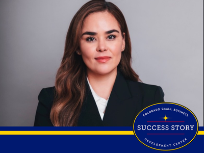 a person in a suit standing in front of a gray background.