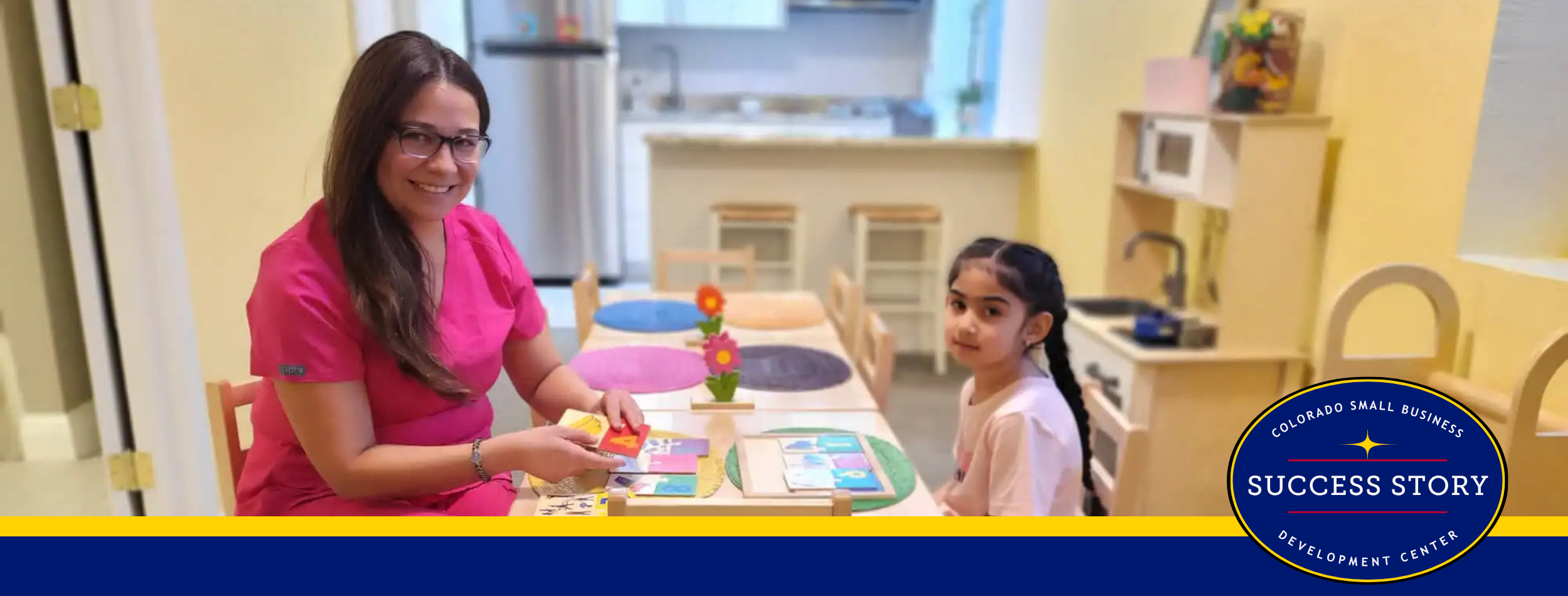 a person in pink is sitting at a table with a child.