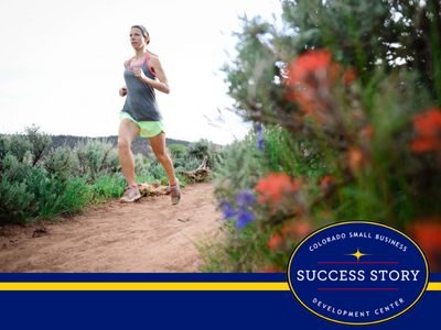 a person is running on a trail through wildflowers.