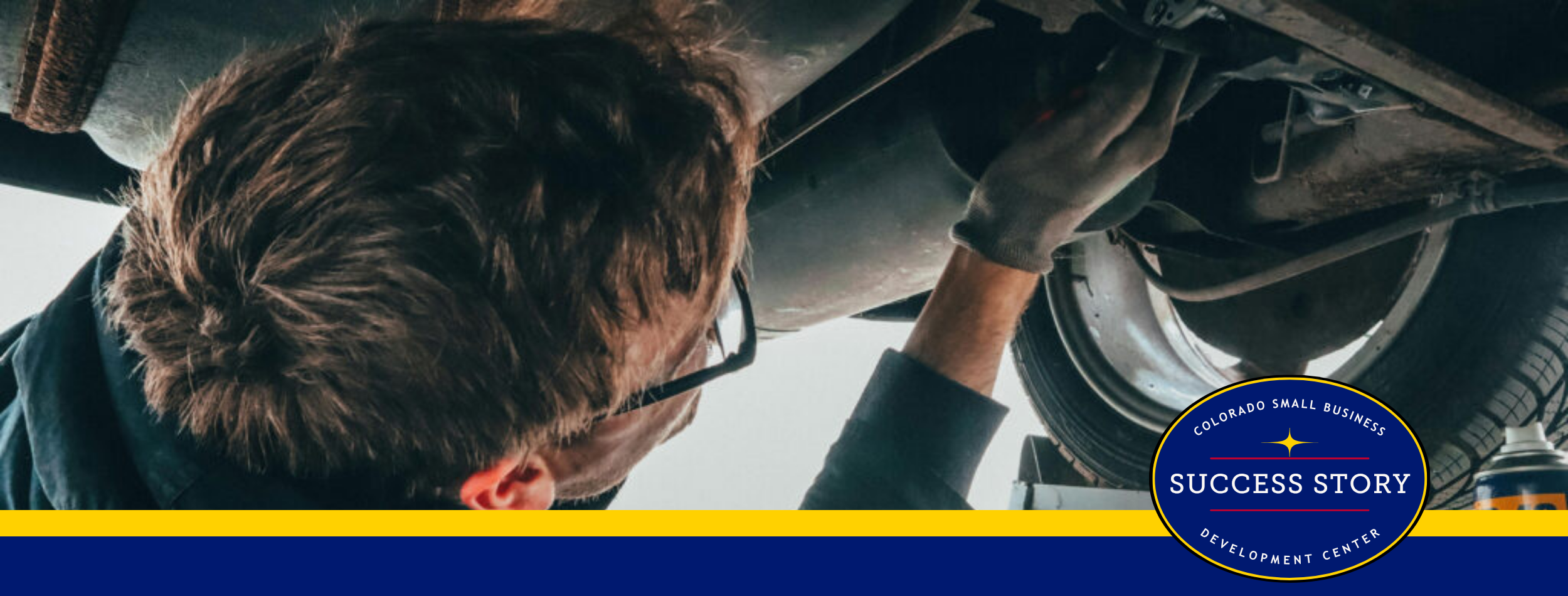 a person is working on the underside of a car.