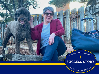 a person sitting on a log next to a dog.