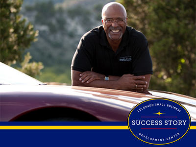 a person in black shirt sitting on top of a sports car.