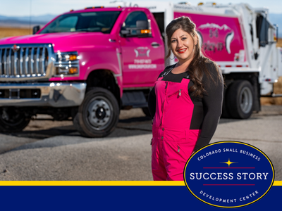 a person in pink overalls standing in front of a pink garbage truck.