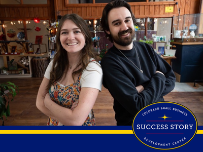 Two people standing in front of a store.