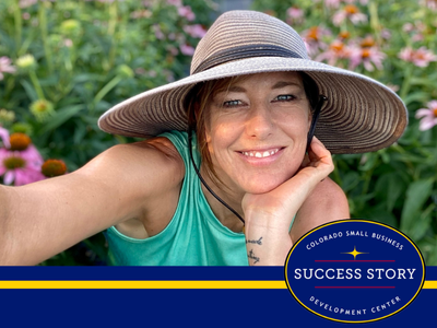 A person wearing a hat in a field of flowers.