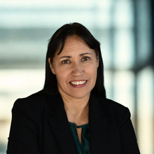 person in black blazer smiling 