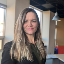 A person with long hair standing in an office.