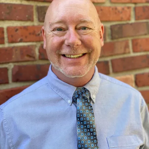 A person wearing a blue shirt and blue tie.