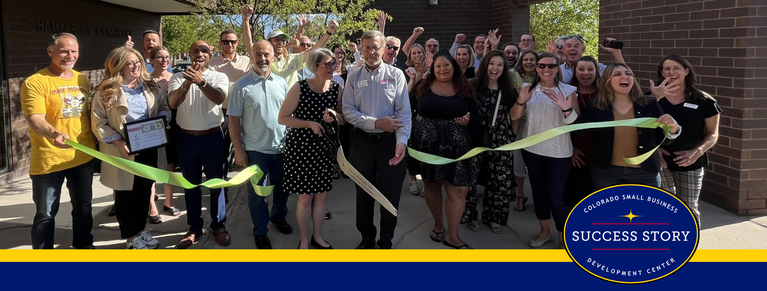 a group of people cutting a ribbon in front of a building.