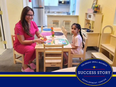 a person in pink is sitting at a table with a child.
